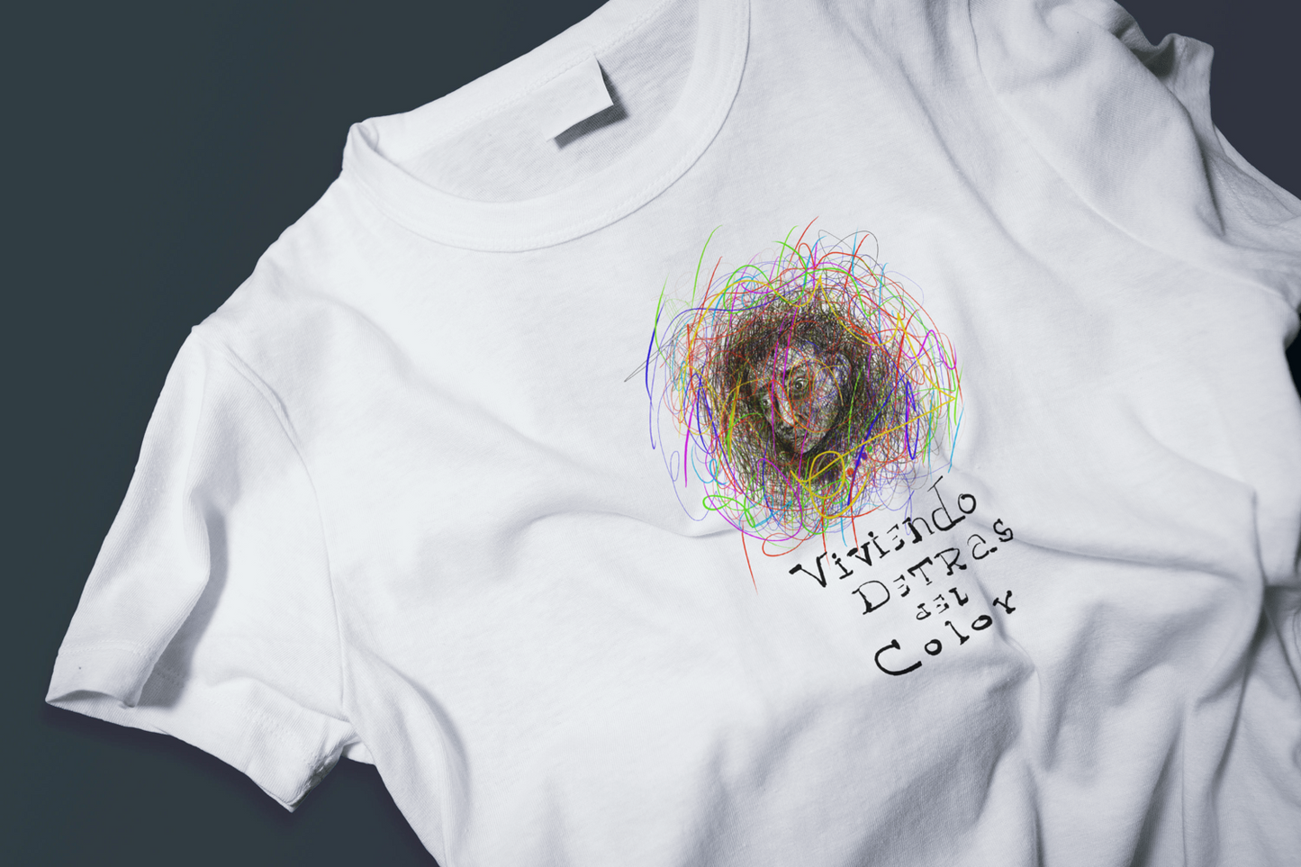 White t-shirt with digital illustration of a human face surrounded 
by explosive colorful lines, titled Living Behind the Color, 
by Cuban artist Rogelio García Miami
