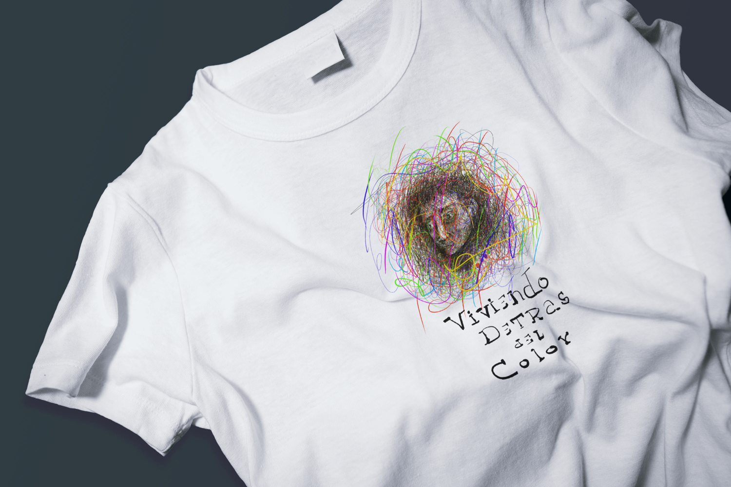 White t-shirt with digital illustration of a human face surrounded 
by explosive colorful lines, titled Living Behind the Color, 
by Cuban artist Rogelio García Miami